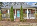 Inviting brick home with a bright turquoise front door and classic white railing, offering a cozy entry at 117 Maple Hill Rd, Monroe, NC 28110