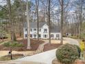Beautiful home with a winding driveway and lush landscaping nestled among mature trees for added privacy at 125 High Sail Ct, Mooresville, NC 28117