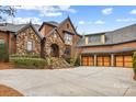 Charming home with stone and brick exterior, well-maintained landscaping, and inviting curb appeal at 1312 Lookout Cir, Waxhaw, NC 28173