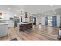 Open living space with modern kitchen island, stainless appliances, and wood-look floors at 1536 Plyler Lake Rd, Gastonia, NC 28054