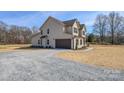 Wide view of home exterior with attached garage, gravel driveway, and well kept landscaping at 2622 Old Camden Rd, Monroe, NC 28110