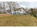 An eye-level view of a single-story home with light gray siding and a modest front yard at 305 Flat Rock St, Clover, SC 29710