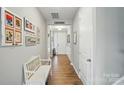 Bright hallway with wood floors, framed pictures, and a bench at 333 Dudley Dr, Fort Mill, SC 29715