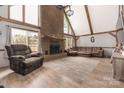 Inviting living room with a brick fireplace, wood-look floors, a comfortable sectional sofa, and large windows at 360 Patience Dr, Concord, NC 28025