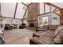 Spacious living room featuring a large brick fireplace, vaulted ceilings with wooden beams, and ample natural light at 360 Patience Dr, Concord, NC 28025