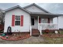 Charming home with a brick foundation and front porch, and a cozy entrance with a storm door and red shutters at 376 Brookgreen Nw Pl, Concord, NC 28027