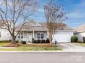 Inviting one-story home showcases an attached two-car garage, landscaped front yard, and a covered front porch at 415 Ridgely Green Dr, Pineville, NC 28134