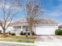 Inviting one-story home showcases an attached two-car garage, landscaped front yard, and a covered front porch at 415 Ridgely Green Dr, Pineville, NC 28134