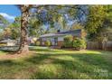 Well-maintained lawn and mature trees surround this cozy single-story home at 4635 General Pershing Dr, Charlotte, NC 28209