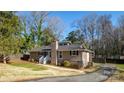 Charming home with a brick chimney, wood siding, and a driveway leading to the side of the house at 5615 Starkwood Dr, Charlotte, NC 28212