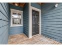 Inviting condo doorway featuring a wood porch, classic trim, and dark front door at 623 Olmsted Park Pl # D, Charlotte, NC 28203