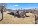 Brick ranch home with a cozy front porch, mature trees, and detached garage on a sunny day at 6285 Nc 16 N Hwy, Taylorsville, NC 28681