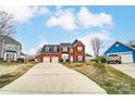 Wide view of a brick two-story home featuring a spacious driveway and traditional suburban setting at 12332 Ridge Cove Cir, Charlotte, NC 28273