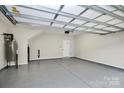 Spacious garage with sealed concrete floors, white walls and door, and overhead lighting perfect for storage and parking at 1270 Brawley School Rd # E, Mooresville, NC 28177