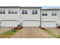 Three white garages offer ample parking and storage, set against a backdrop of green grass and a concrete driveway at 1270 Brawley School Rd # E, Mooresville, NC 28177