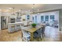 Open-concept living space with modern kitchen, dining area, and cozy living room featuring large windows at 13935 Penbury Ln # 378, Charlotte, NC 28278