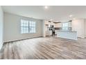 Open-concept living space with wood flooring, filled with natural light near the kitchen area at 1402 Pine Heart Dr, Edgemoor, SC 29712