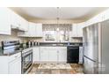 Bright kitchen with white cabinets, stainless steel appliances, and a charming window view at 1911 Woodlawn St, Kannapolis, NC 28083