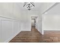 Bright living room featuring wood floors, white wainscoting, and a modern light fixture at 1915 Kingston Dr, Gastonia, NC 28052