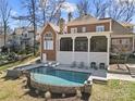 Elevated pool area with a stone surround and nearby screened-in porch, offering a serene backyard retreat at 20338 Christofle Dr, Cornelius, NC 28031