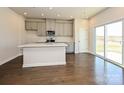 Bright kitchen with hardwood flooring, island, gray cabinets, and stainless appliances at 2108 Morgan Hills Dr, Albemarle, NC 28001