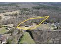 Aerial view of a home on a wooded lot, complete with a pool and circular driveway at 257 Hickory Hill Ln, Stanley, NC 28164