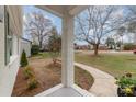 Covered front porch showing brick support columns and a glimpse of the surrounding neighborhood at 3504 Meredith Ave, Charlotte, NC 28208