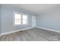 Light-filled bedroom with gray walls, white trim and doors, and light gray wood-look flooring at 4211 Little Mountain Rd, Gastonia, NC 28056