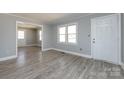 Bright living room featuring gray walls, white trim, and durable light gray wood-look flooring at 4211 Little Mountain Rd, Gastonia, NC 28056