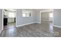 Open-concept layout with light gray wood-look flooring connecting the living room and kitchen at 4211 Little Mountain Rd, Gastonia, NC 28056