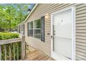 Charming exterior detail of house entrance featuring wooden deck, door, and classic siding at 5128 Green Leaf Ct, Mount Holly, NC 28120