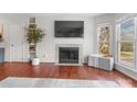 Bright living room showcases a fireplace with mounted television and a large window offering natural light at 529 N Graham St # 2G, Charlotte, NC 28202