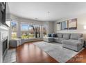 Beautifully lit living room with fireplace and view of green space beyond the large window at 529 N Graham St # 2G, Charlotte, NC 28202