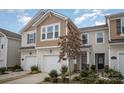 Attractive townhome showing well manicured landscaping, single-car garage, and classic design elements at 5532 Axil Ln, Charlotte, NC 28269