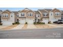 Street view of craftsman-style townhomes, each with a single-car garage and manicured lawns at 5532 Axil Ln, Charlotte, NC 28269