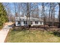 Charming ranch-style home featuring a well-manicured lawn, mature trees, and a classic white facade at 6215 Coatbridge Ln, Charlotte, NC 28212