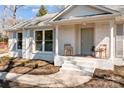 Inviting front porch of a charming brick home, with stylish chairs, and fresh landscaping at 6215 Coatbridge Ln, Charlotte, NC 28212