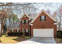 Beautiful two-story brick home showcasing a well-maintained exterior with a two-car garage and mature trees at 7562 Sedgebrook W Dr, Stanley, NC 28164