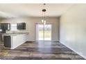 View of eat-in kitchen featuring hardwood floors and a sliding glass door to the back yard at 8247 Pozzi Rd, Charlotte, NC 28216