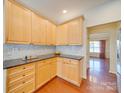 Bright kitchen boasts granite countertops, wood cabinets, and a seamless backsplash design at 9684 Ravenscroft Nw Ln, Concord, NC 28027