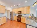 Well-lit kitchen featuring stainless steel appliances, granite countertops, and wood cabinets at 9684 Ravenscroft Nw Ln, Concord, NC 28027