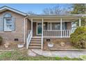 Inviting covered front porch with white railings and brick steps leading to the entrance at 12 Roberta Rd, Concord, NC 28027