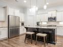 Modern kitchen with white cabinets, granite countertops, stainless steel appliances, and an island at 12432 Bradford Park Dr, Davidson, NC 28036