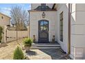 A sophisticated front entrance featuring a dark-colored door flanked by decorative stone statues and manicured landscaping at 1414 Biltmore Dr, Charlotte, NC 28207