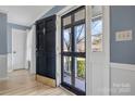 Bright foyer featuring hardwood floors, blue walls, white trim, and a view of the outdoors through a glass front door at 1417 Shady Bark Dr, Gastonia, NC 28054