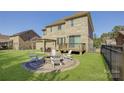 Expansive backyard with a fire pit, outdoor seating, and a pergola-covered dining area at 17809 Pawleys Plantation Ln, Charlotte, NC 28278