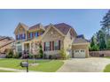 Beautiful two-story brick home featuring an attached two-car garage and manicured lawn at 17809 Pawleys Plantation Ln, Charlotte, NC 28278