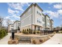 Beautiful townhome exterior featuring mixed siding, brick, professional landscaping, wrought iron fencing and a stone retaining wall at 2021 Summey Ave, Charlotte, NC 28205