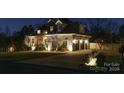 Exterior nighttime shot of a beautiful home with stone accents, side-entry garage, and manicured landscaping at 2036 Rocky Stream Rd, York, SC 29745