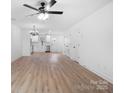 Spacious living room with wood-look floors, a modern light fixture, and a connecting kitchen at 211 E Rice St, Landis, NC 28088